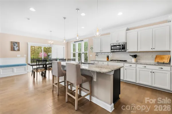 a kitchen with appliances a sink a counter top space and a center island