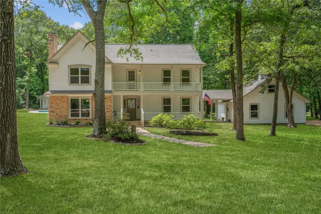 a front view of a house with a yard and trees