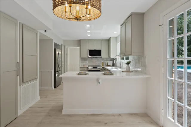 a view of kitchen with stainless steel appliances granite countertop a stove and a refrigerator