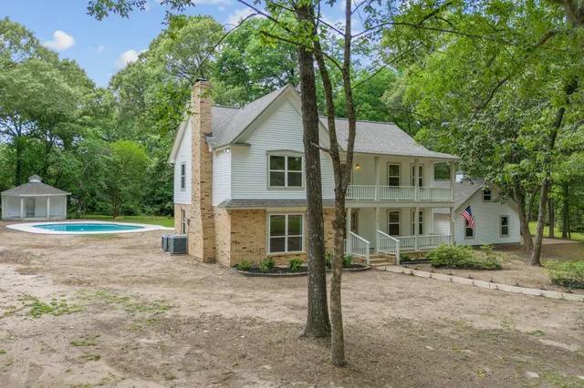 a front view of a house with a garden and trees