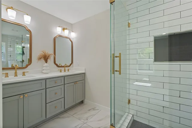 a bathroom with double vanity sinks and a mirror