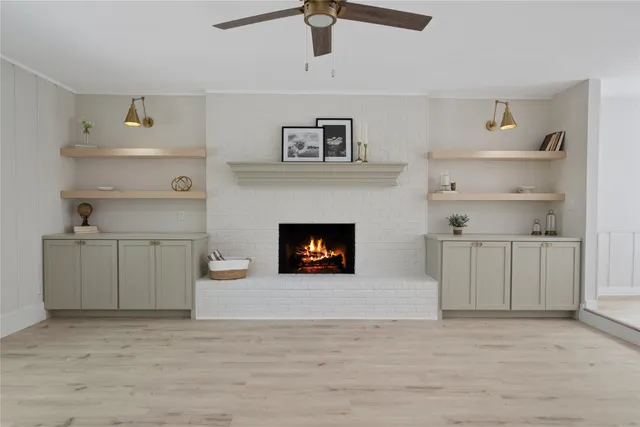 a view of a kitchen with white cabinets and a fireplace