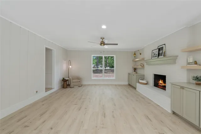 a view of an empty room with window and fire place