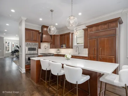 a kitchen with a dining table chairs and wooden floor