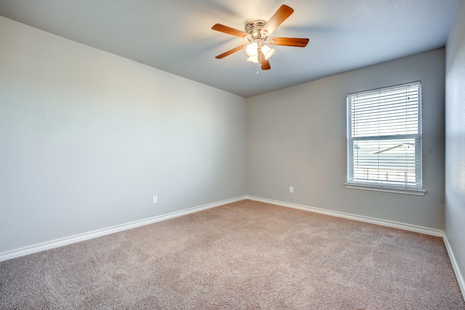3450 Itasca Street Lubbock, TX 79415 - Photo 13 of 24 an empty room with windows and chandelier fan