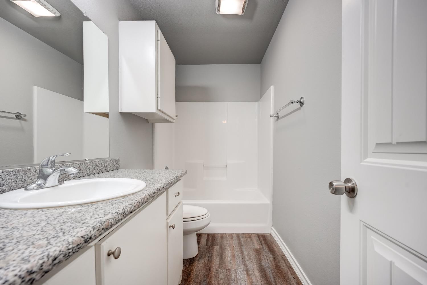 3450 Itasca Street Lubbock, TX 79415 - Photo 15 of 24 a bathroom with a granite countertop sink toilet and shower