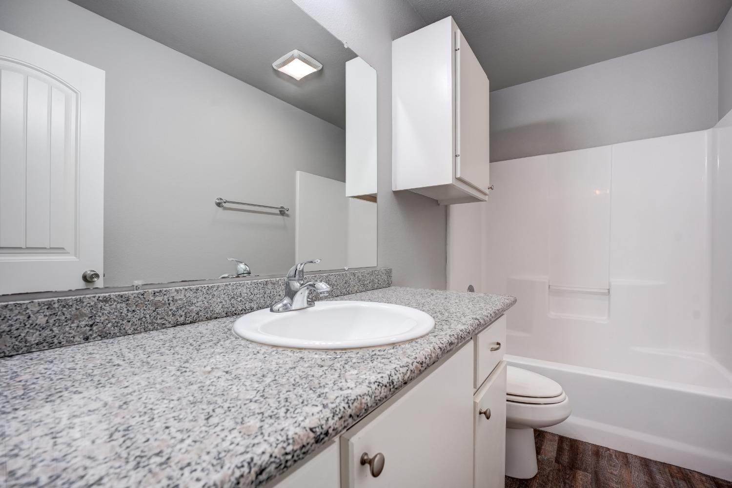 3450 Itasca Street Lubbock, TX 79415 - Photo 16 of 24 a bathroom with a granite countertop sink a toilet and a bathtub