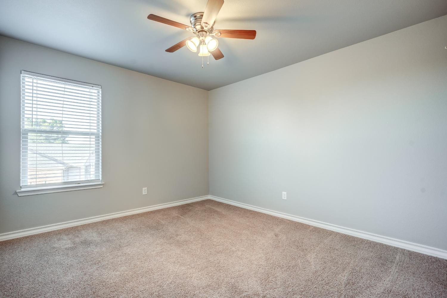 3450 Itasca Street Lubbock, TX 79415 - Photo 18 of 24 an empty room with a window and a fan