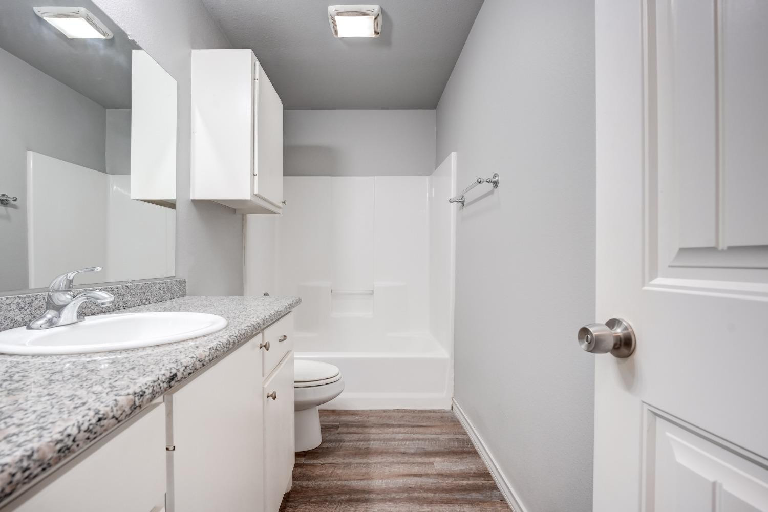 3450 Itasca Street Lubbock, TX 79415 - Photo 19 of 24 a bathroom with a granite countertop sink a toilet and bathtub