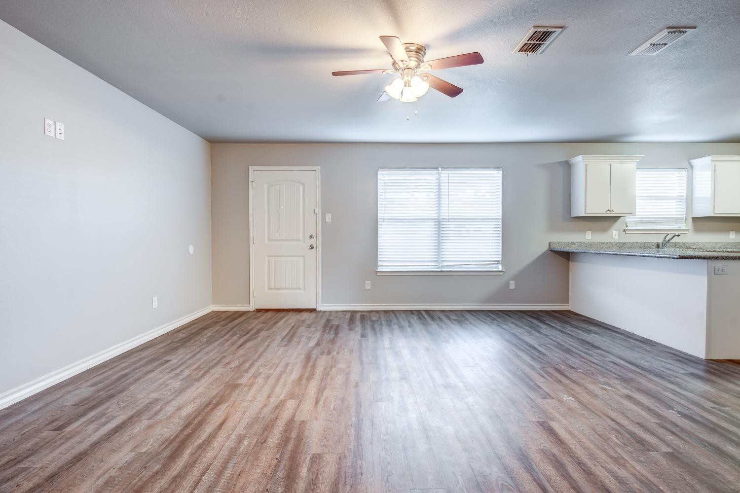 3450 Itasca Street Lubbock, TX 79415 - Photo 3 of 24 wooden floor in an empty room with a window