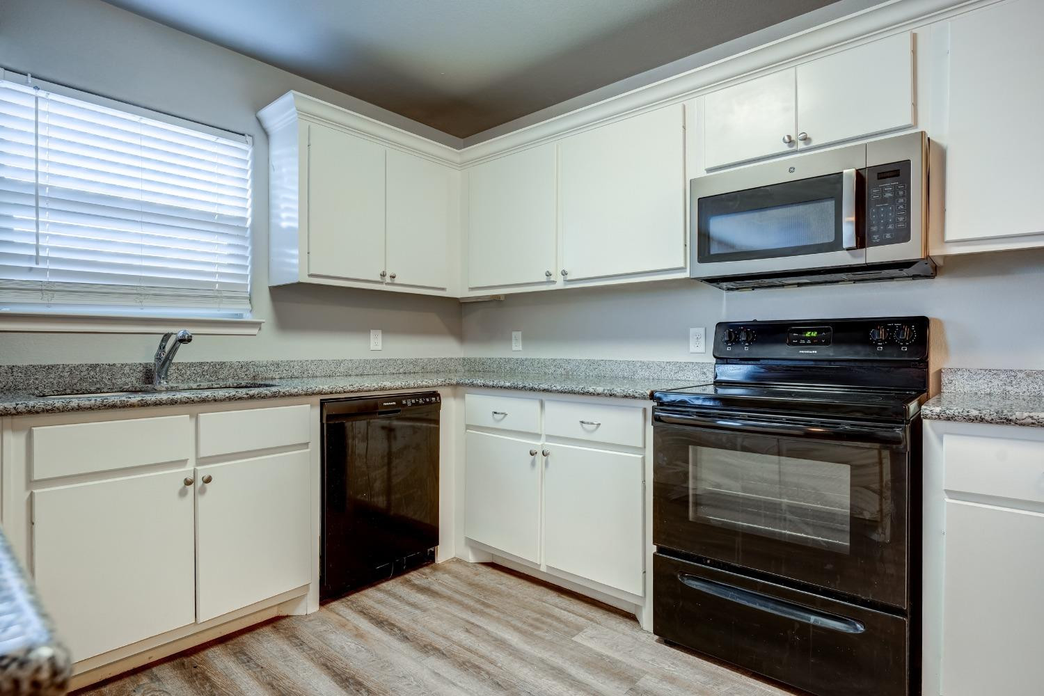 3450 Itasca Street Lubbock, TX 79415 - Photo 10 of 24 a kitchen with stainless steel appliances granite countertop a stove microwave and sink