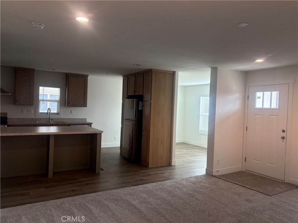 4361 Mission Boulevard, Unit 151 Montclair, CA 91763 - Photo 13 of 39 an empty room with kitchen view and wooden floor