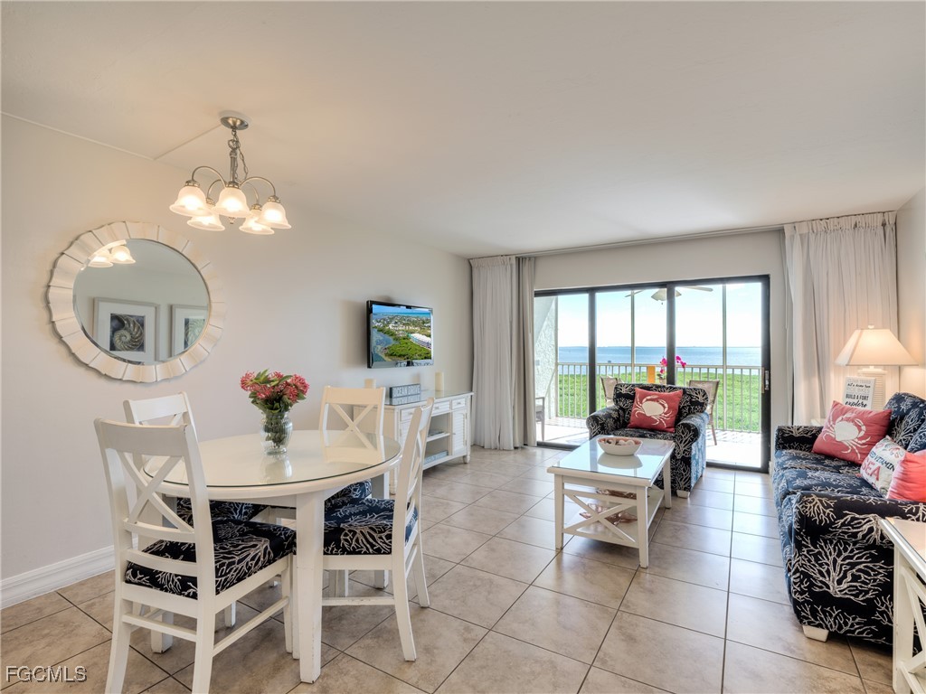 5232 Bayside Villas Captiva, FL 33924 - Photo 5 of 29 a dining room with furniture a rug and a chandelier