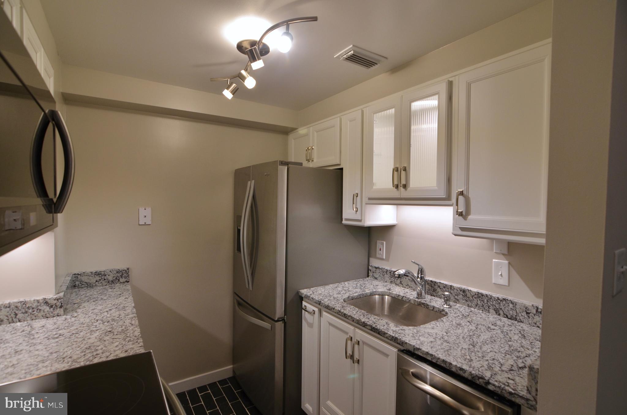 2114 N Street Northwest, Unit 2 Washington, DC 20037 - Photo 5 of 24 a kitchen with stainless steel appliances granite countertop a sink stove and refrigerator