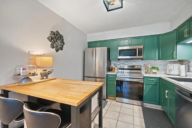 a kitchen with kitchen island a sink appliances and cabinets