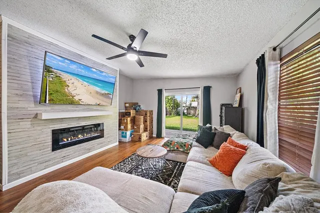 a living room with furniture a fireplace and a large window