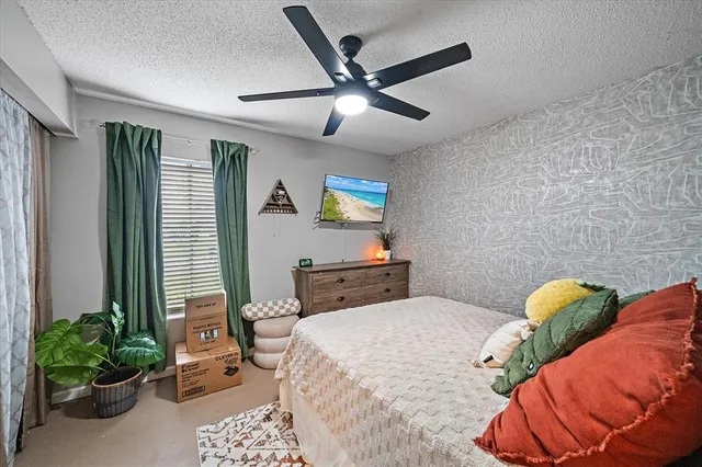 a bedroom with a bed and ceiling fan
