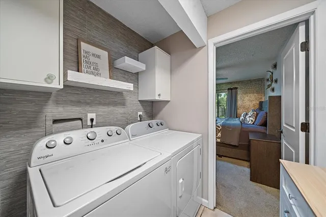 a utility room with dryer washer and a view of kitchen