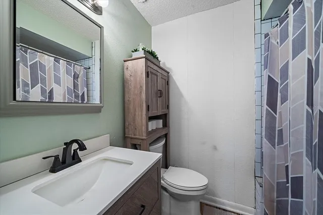 a bathroom with a sink toilet and mirror