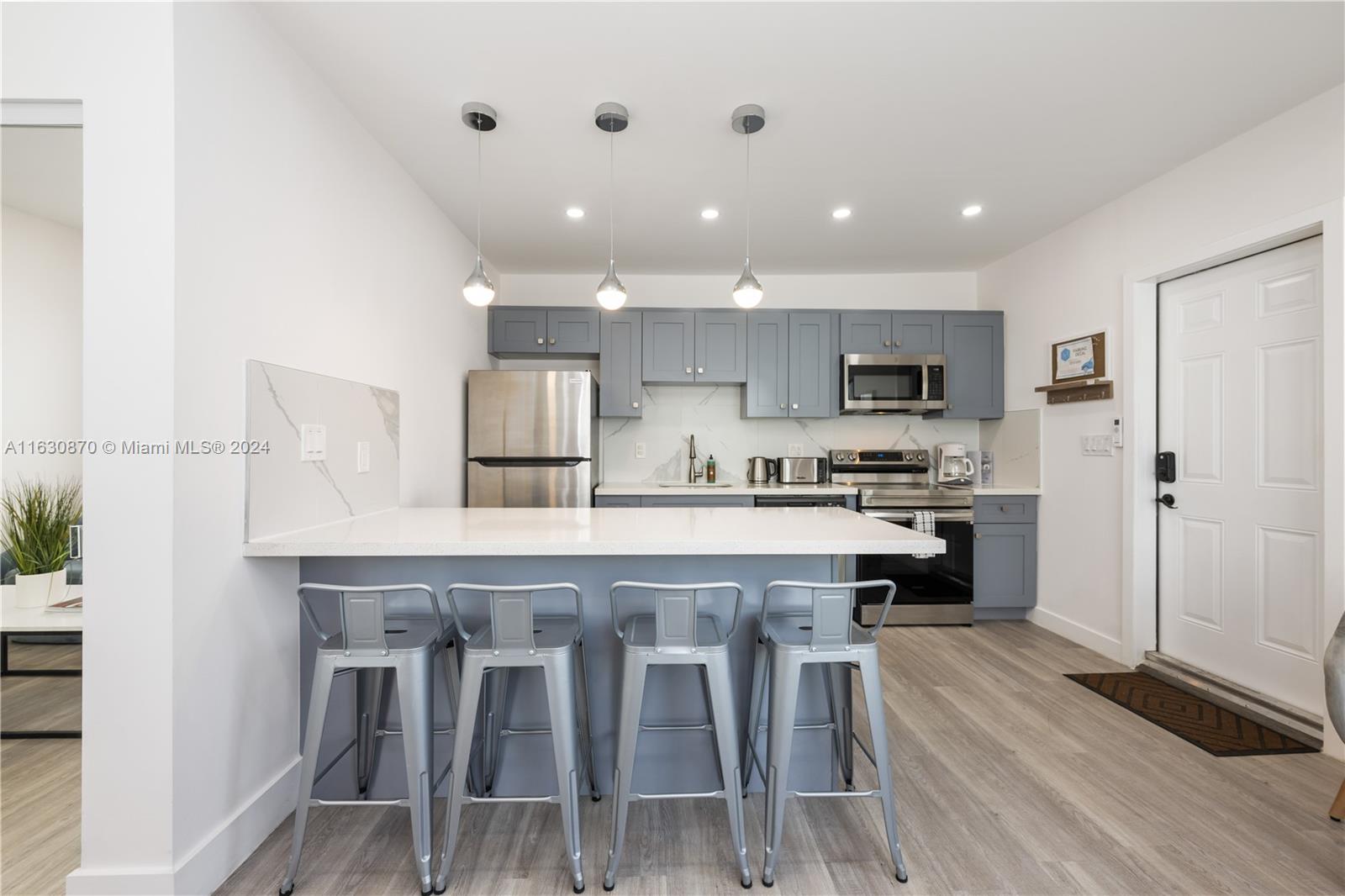 1648 Southwest 7th Street Miami, FL 33135 - Photo 15 of 23 a kitchen with kitchen island white cabinets and stainless steel appliances