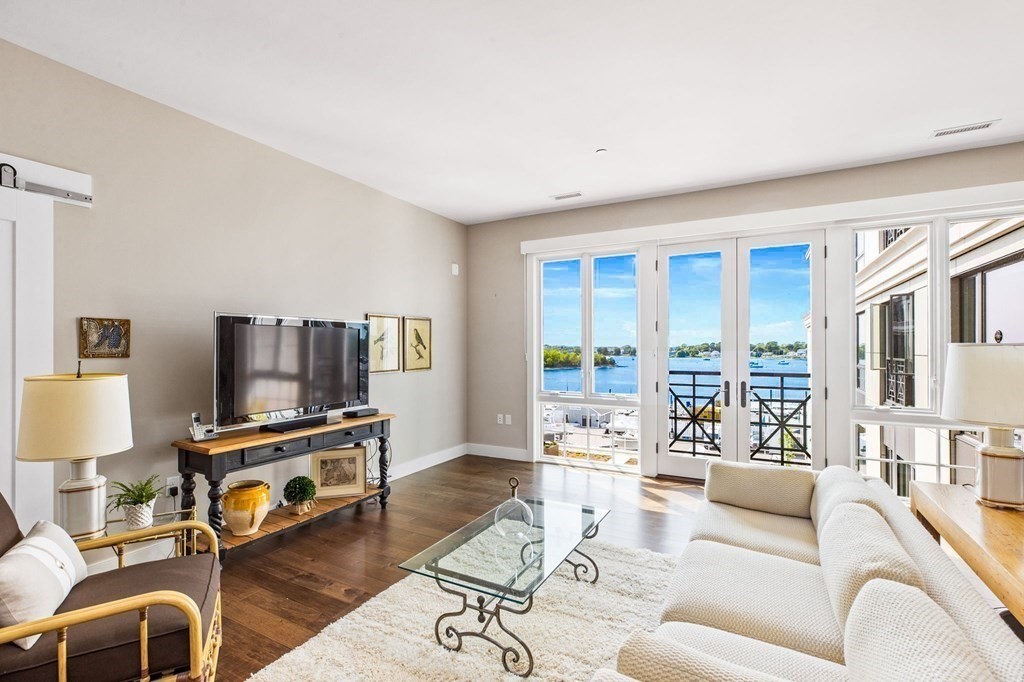 a living room with furniture flat screen tv and a large window