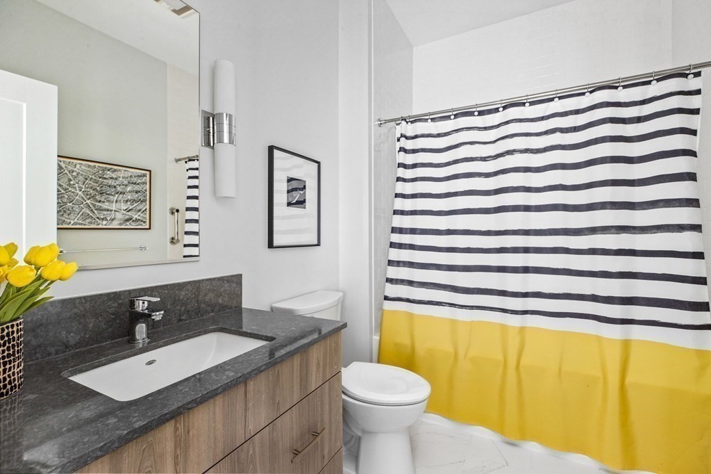 10 Shipyard Drive, Unit 408 Hingham, MA 02043 - Photo 16 of 26 a bathroom with a sink a toilet and a mirror