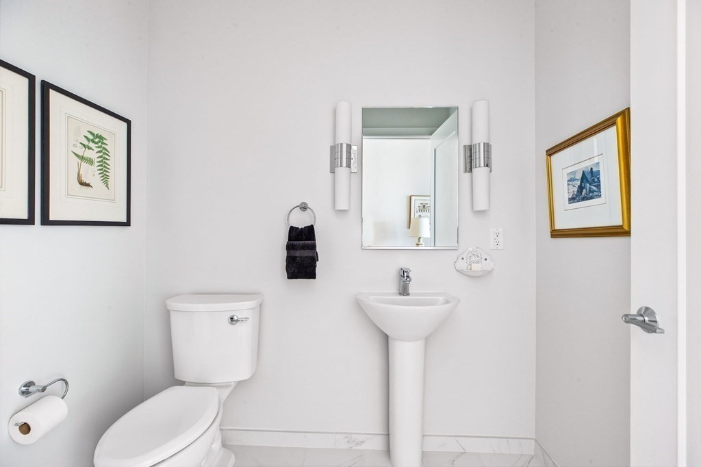 10 Shipyard Drive, Unit 408 Hingham, MA 02043 - Photo 10 of 26 a white toilet sitting next to a bathroom sink