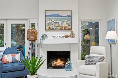 a living room with furniture a fireplace and a potted plant