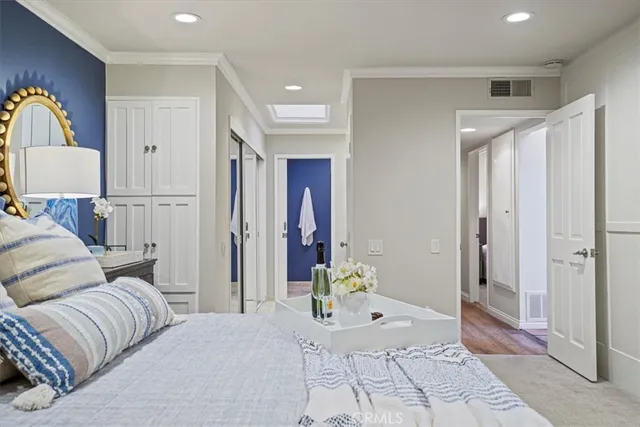 a spacious bedroom with a bed and a flat screen tv