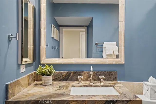 a bedroom with a bed a lamp and mirror