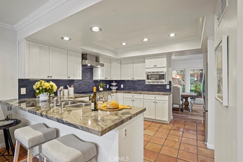 23802 Cassandra Bay Dana Point, CA 92629 - Photo 9 of 56 a kitchen with kitchen island granite countertop a sink cabinets and counter space
