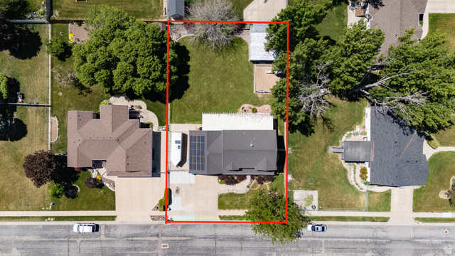 5727 South 3550th Street West Roy, UT 84067 - Photo 43 of 49 Aerial property view featuring a dark shingle roof, a paved driveway, and established landscaping