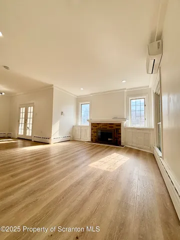 a view of empty room with wooden floor and fireplace