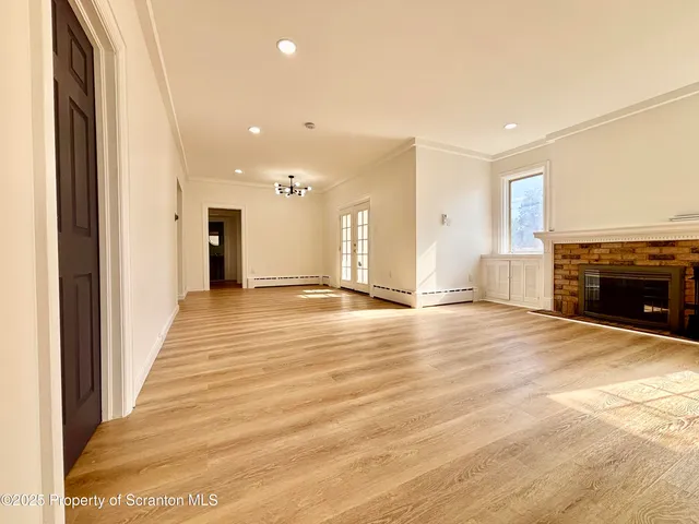 an empty room with wooden floor and fireplace