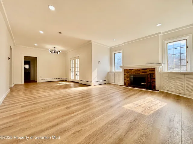 an empty room with wooden floor and fireplace