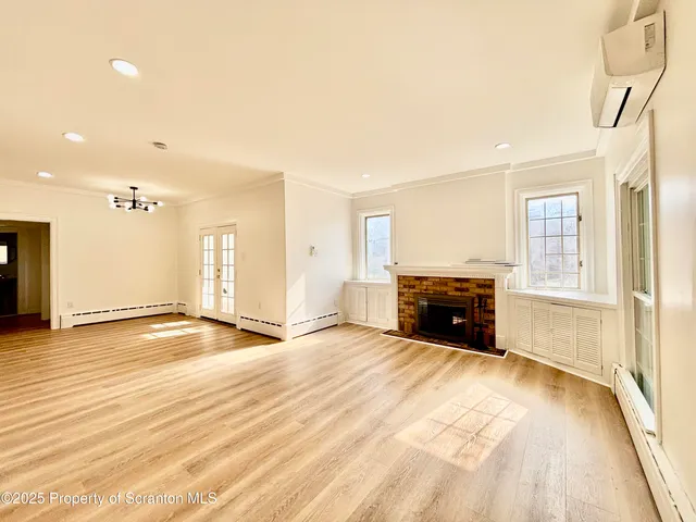 a view of an empty room with a fireplace and a window