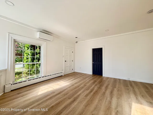 a view of a room with wooden floor and window