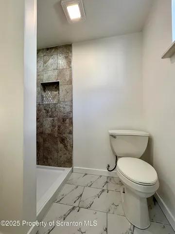 a bathroom with a toilet and a shower