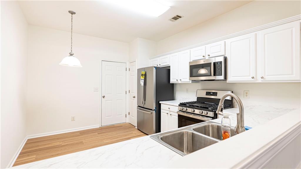 2070 Hailston Drive Northwest Duluth, GA 30097 - Photo 12 of 42 a kitchen with stainless steel appliances a stove a sink and a refrigerator