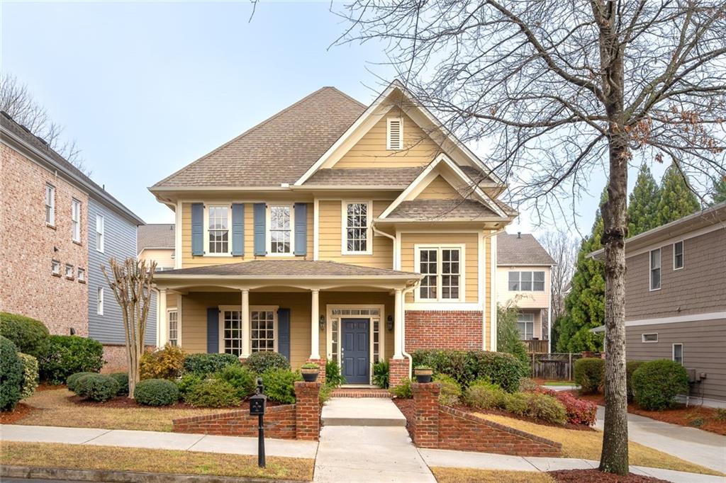 a front view of a house with plants and trees