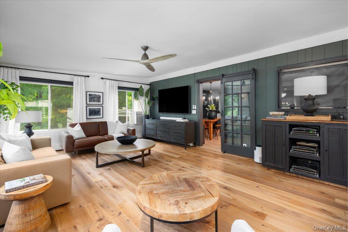 13 Jacks Pond Road Newburgh, NY 12550 - Photo 14 of 44 Inviting family great room with light wood-finish flooring, a sleek contemporary ceiling fan, and expansive windows offering abundant natural light.