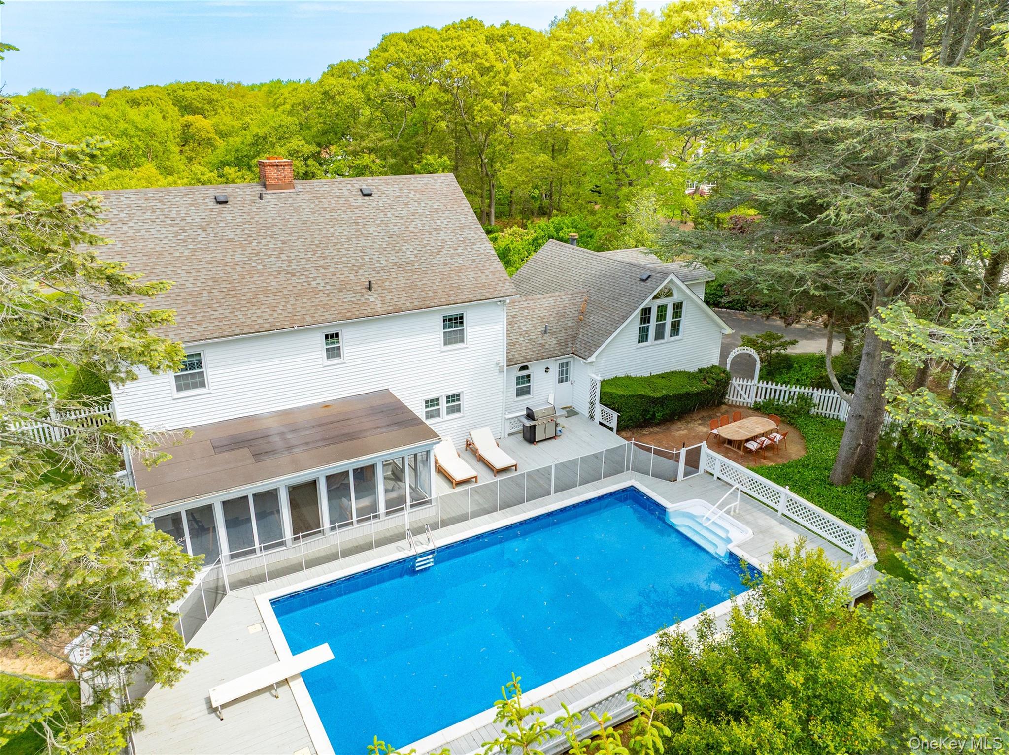 View of swimming pool with a patio, a diving board, a sunroom, and a fenced backyard