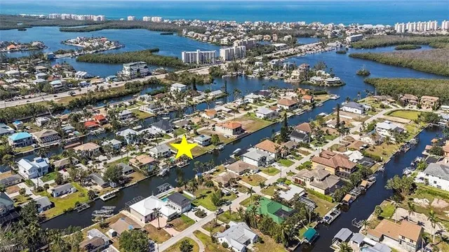 an aerial view of ocean and residential houses with outdoor space