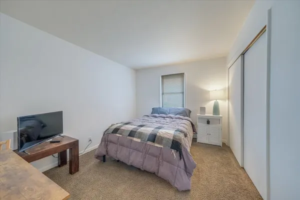 a bedroom with a bed and flat screen tv