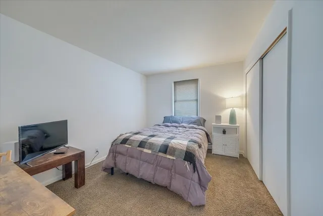 a bedroom with a bed and flat screen tv