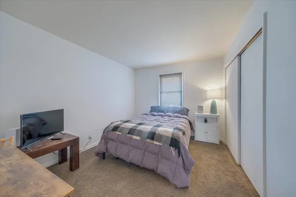 a bedroom with a bed and flat screen tv