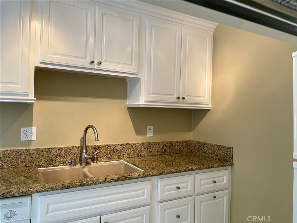 1000 West MacArthur Boulevard, Unit 87 Santa Ana, CA 92707 - Photo 5 of 36 a kitchen with granite countertop white cabinets and a sink