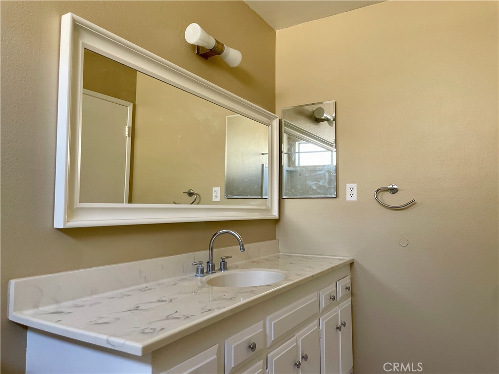 1000 West MacArthur Boulevard, Unit 87 Santa Ana, CA 92707 - Photo 10 of 36 a bathroom with a granite countertop sink and a mirror