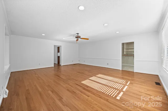 a view of an empty room with wooden floor and cabinet