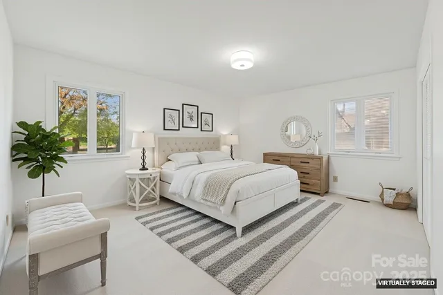 a bedroom with a large bed and a potted plant